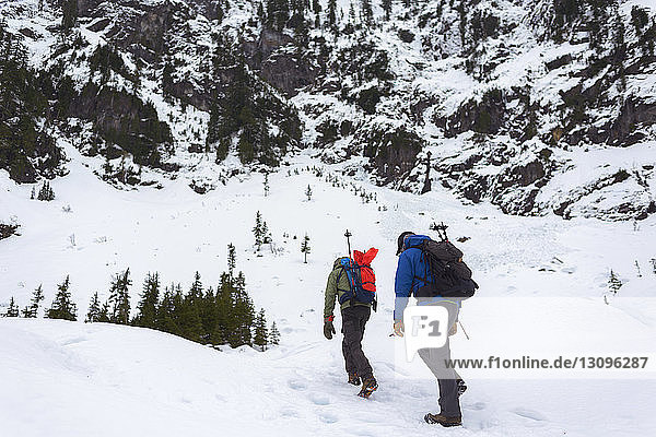 Friends hiking on snow covered hill
