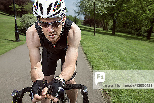 Porträt eines selbstbewussten Radfahrers  der auf dem Fahrrad inmitten des Feldes sitzt
