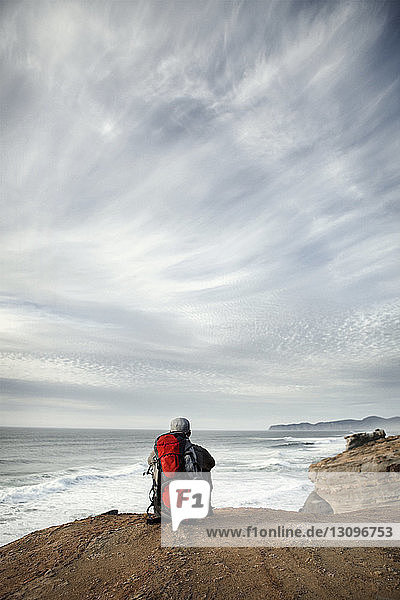 Man sitting on edge of cliff