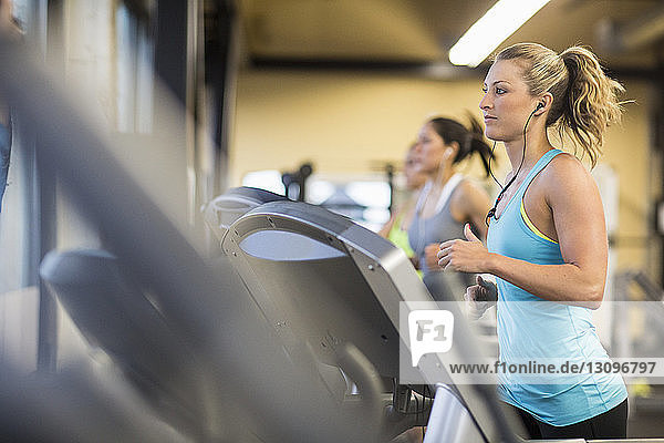 Frauen trainieren auf Laufbändern im Fitnessstudio