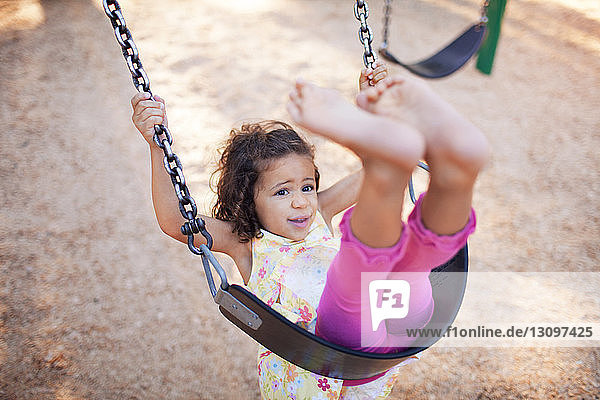 Girl swinging in playground