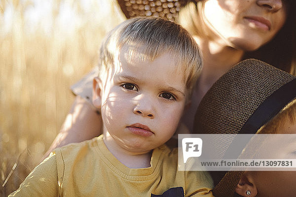 Portrait of cute boy with mother and brother on field