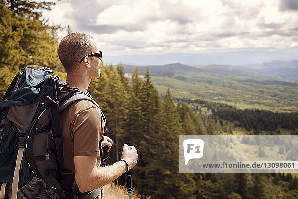 Hiker looking at view while standing on mountain