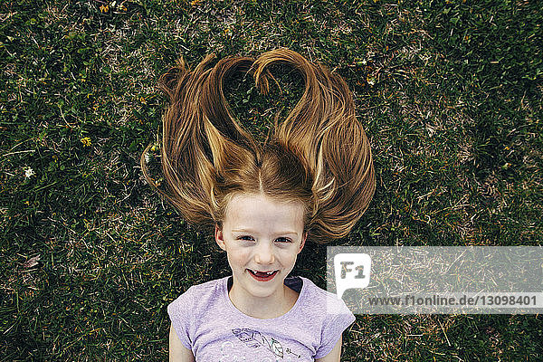 Porträt eines glücklichen Mädchens auf dem Feld liegend