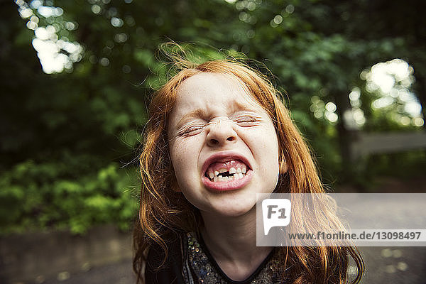 Close-up of girl clenching teeth at park