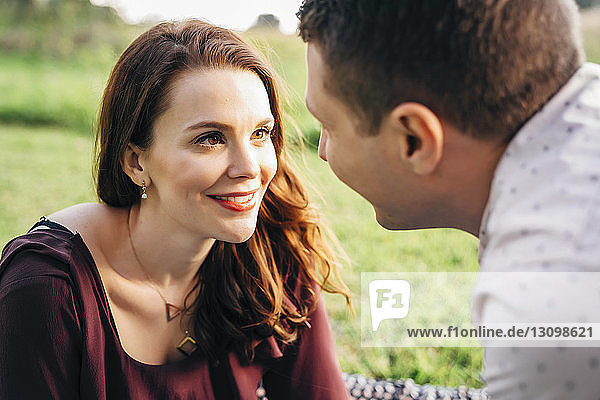 Close-up of smiling couple looking at each other in park