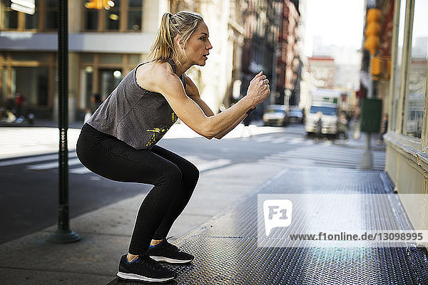 Selbstbewusster Sportler trainiert auf dem Bürgersteig in der Stadt