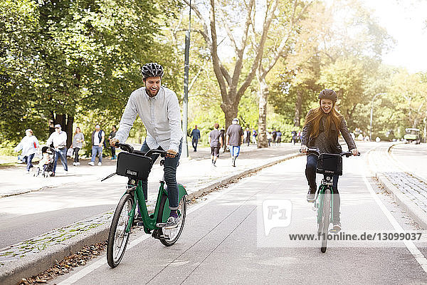 Happy couple riding bicycle in park