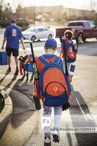 Rückansicht von Jungen und Baseballtrainer auf der Straße
