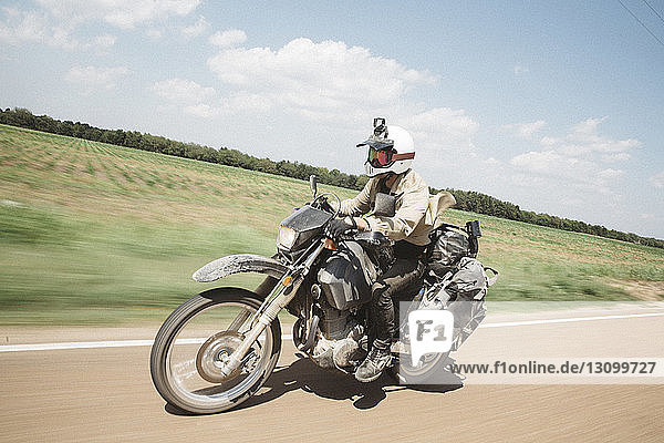 Unbeschwertes Motorradfahren auf unbefestigter Straße gegen den Himmel