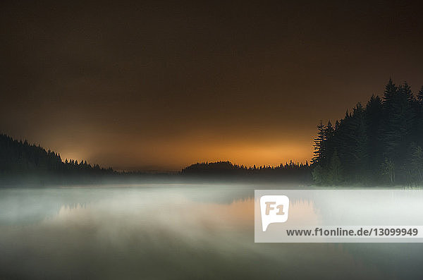 Lange Exposition des Nebels über dem See im Mt Hood National Forest gegen den Himmel bei Sonnenuntergang
