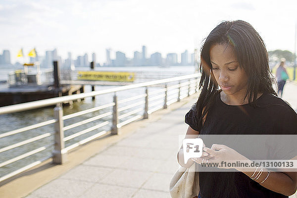 Woman text messaging while standing at promenade