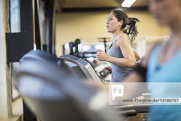 Frauen trainieren auf Laufbändern im Fitnessclub