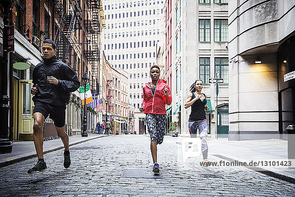 Determined athletes running on city street