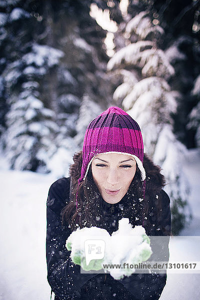 Junge Frau  die Schnee bläst