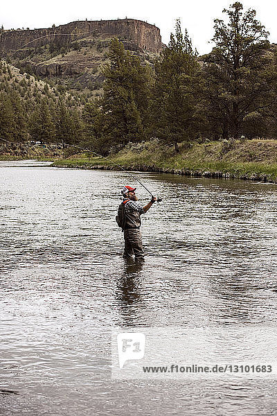 Side view of mature man fishing in river