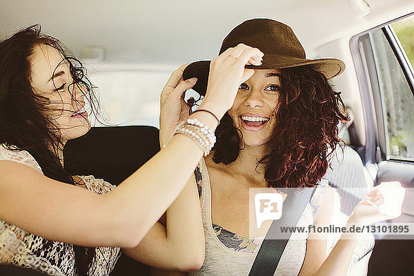 Happy female friends traveling in car