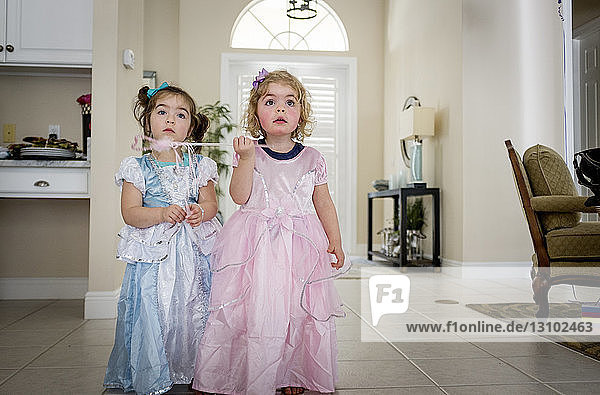 Sisters in dress standing at home