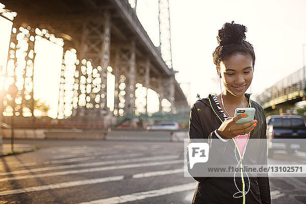 Female jogger listening to music on city street