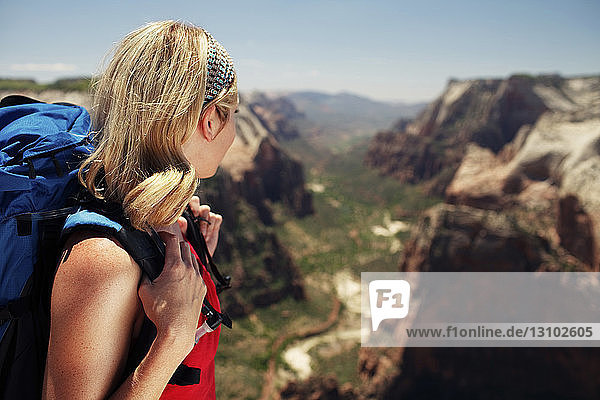 Seitenansicht einer Frau  die den Blick vom Berg aus betrachtet