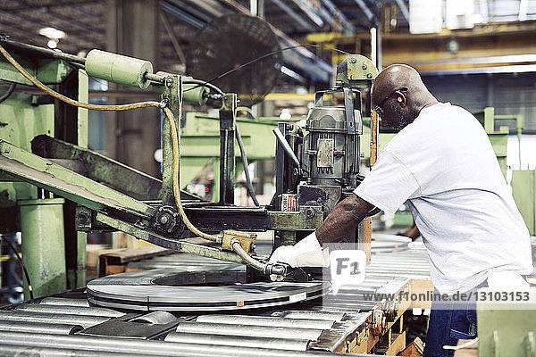 Handarbeiter benutzt Maschine zum Binden von Stahl in der Fabrik