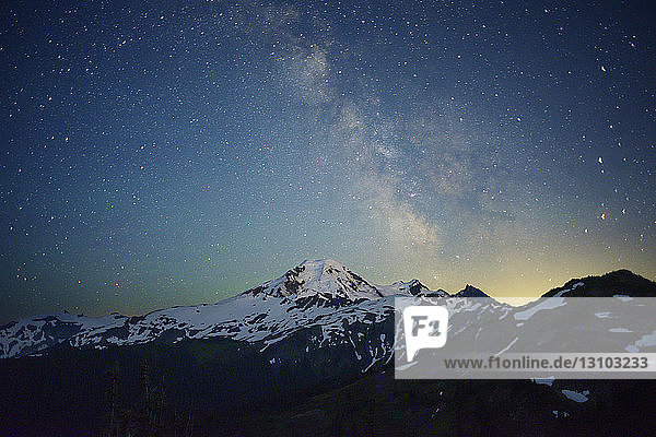 Scenic view of snowcapped mountain against starry sky