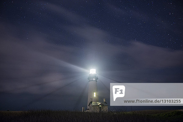 Niederwinkelansicht des beleuchteten Yaquina-Scheinwerfers gegen den Himmel bei Nacht