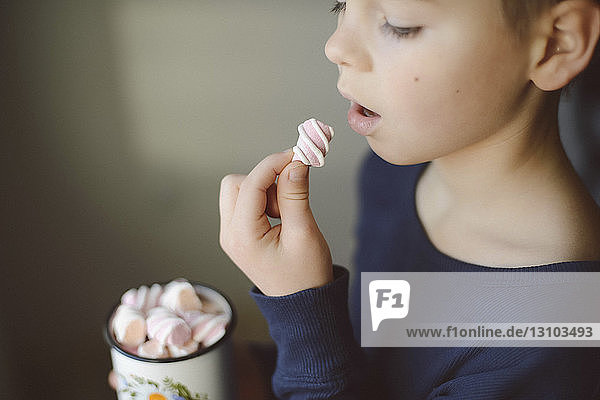 Boy eating marshmallow at home