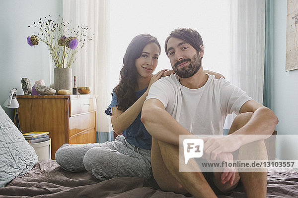Portrait smiling couple relaxing on bed
