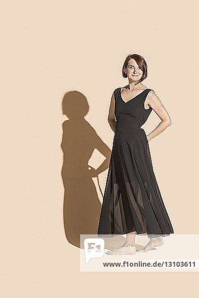 Portrait confident  barefoot woman in black dress