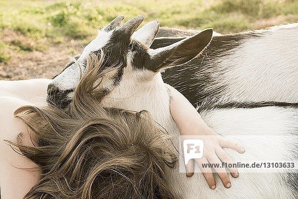Mädchen umarmt Ziege