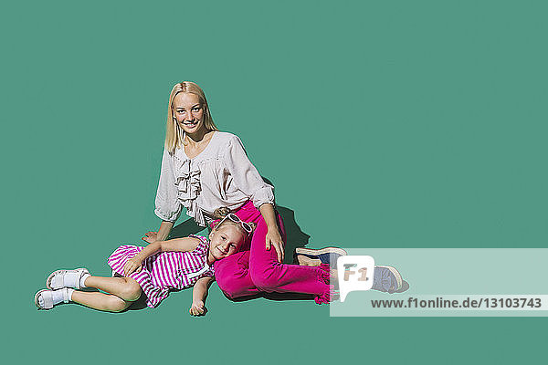 Porträt Mutter und Tochter entspannt auf grünem Hintergrund