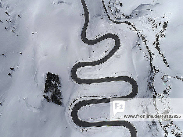Blick von oben über den kurvenreichen Julierpass durch den schneebedeckten Berg  St. Moritz  Schweiz