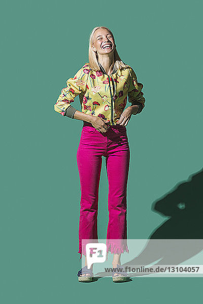 Portrait laughing woman against green background