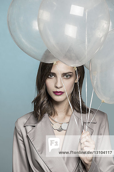 Portrait of female fashion model holding balloons