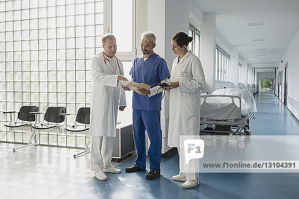 Ärzte besprechen Krankenakte im Krankenhauskorridor