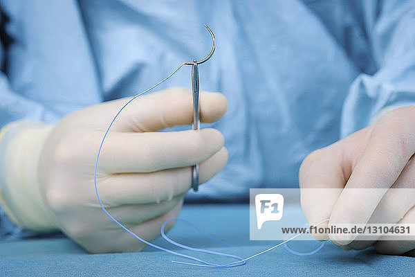 Nahaufnahme: Chirurg hält Nadel