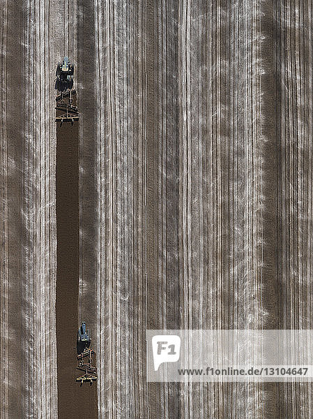 Aerial view agricultural tractors plowing field  Bakersfield  California  USA