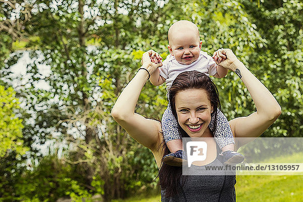 Porträt einer jungen Mutter  die im Sommer viel Zeit mit ihrer Tochter in einem Park verbringt und sie auf den Schultern trägt; Edmonton  Alberta  Kanada