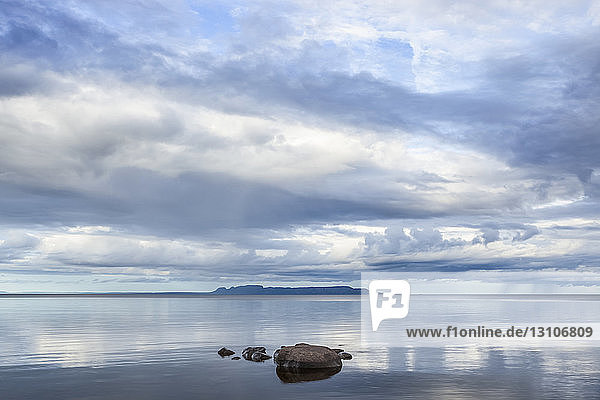 Ruhiger Lake Superior  in dem sich der Himmel spiegelt  mit der Nordküste in der Ferne; Thunder Bay  Ontario  Kanada
