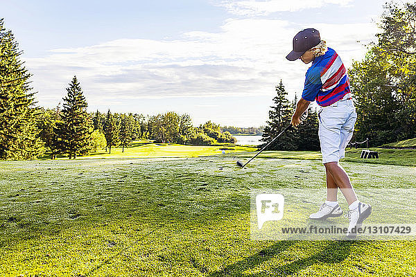 Ein junger männlicher Golfer schlägt während eines Turniers auf einem Golfplatz einen Ball über das Fairway; Edmonton  Alberta  Kanada
