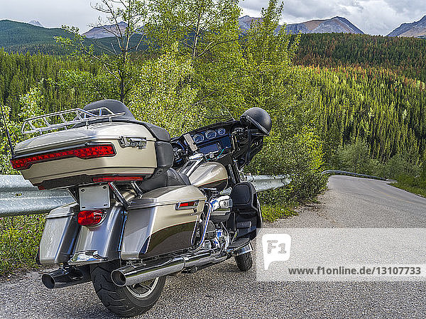 A motorcycle parked on the side of the road with view of the Rocky Mountains  Jasper National Park; Alberta  Canada