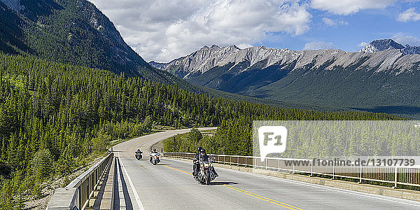 Motorradfahrer fahren auf einer Straße durch die zerklüfteten kanadischen Rocky Mountains im Jasper National Park; Alberta  Kanada