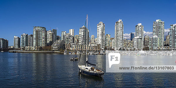 Im Hafen vertäutes Segelboot mit der Skyline von Vancouver entlang der Uferpromenade; Vancouver  British Columbia  Kanada