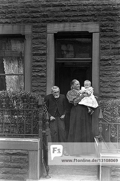 Glasnegativ um 1900.Viktorianisch.Sozialgeschichte. Eine alte Dame und ein Herr an der Tür halten ein Baby