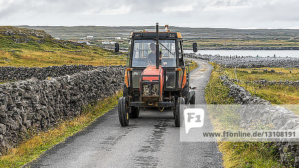 Tractor on the road along the coast of Inishmore on Galway Bay  Aran Islands; Kilronan  County Galway  Ireland