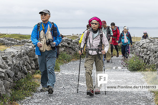 Touristen besuchen die prähistorische Festung Dun Aonghasa  die auf einer hohen Klippe thront  Inishmore  Aran-Inseln; Kilronan  County Galway  Irland