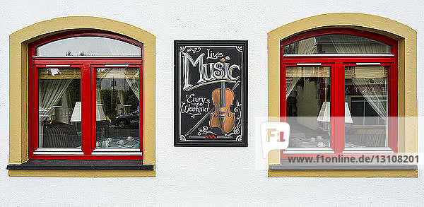 Bunte Außenfenster eines Restaurants mit einem Schild für Live-Musik; County Mayo  Irland