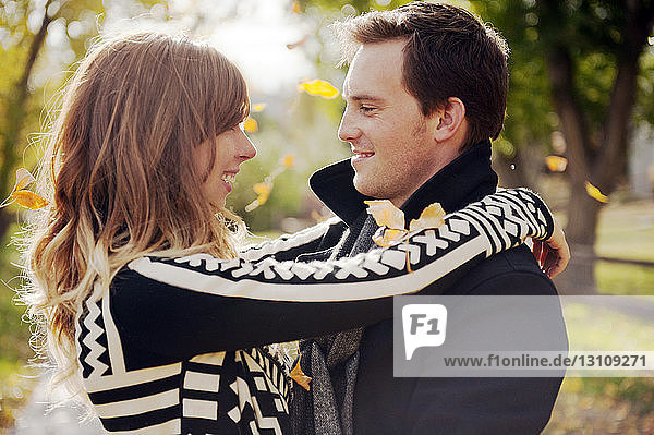 Romantic couple smiling while standing on park