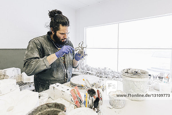 Focused craftsman making craft product at art studio